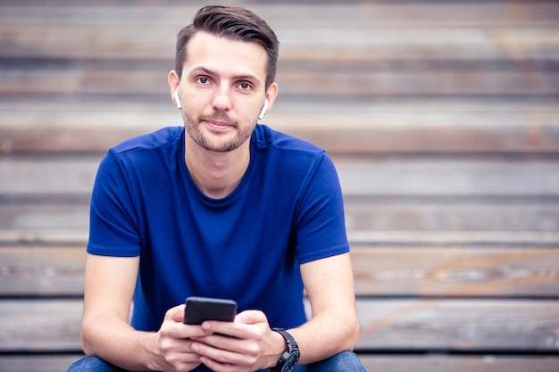 De mens leest tekstbericht op mobiele telefoon tijdens het wandelen in het park