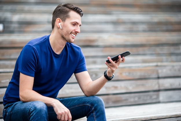 De mens leest tekstbericht op mobiele telefoon tijdens het wandelen in het park