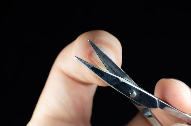 Foto de mens maakt een manicureschaar. procedures thuis. nagels knippen.