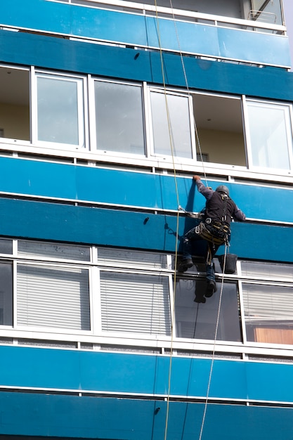 De mens maakt vensters op highrise schoon