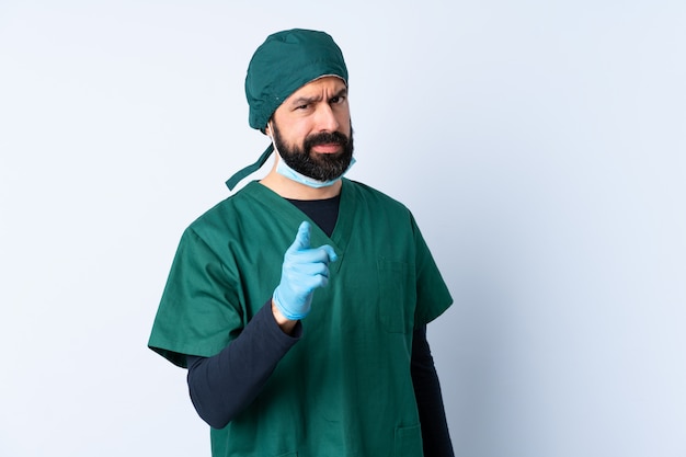 De mens van de chirurg in groen uniform over gefrustreerde muur en het richten