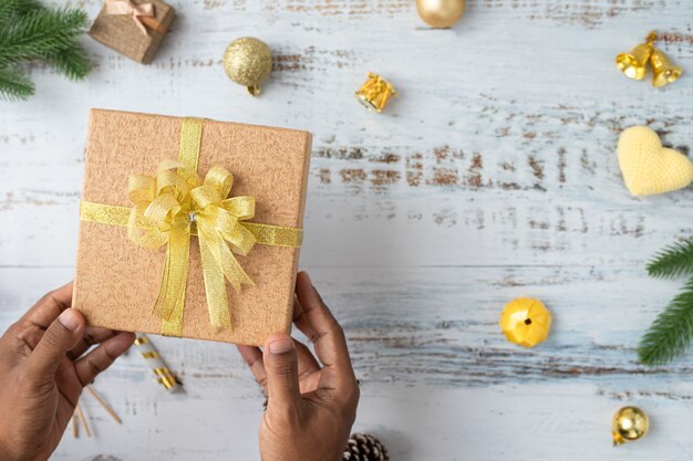 De menselijke doos van de Kerstmisgift van de handgreep met de achtergrond van Kerstmisdecoratie op wit raad