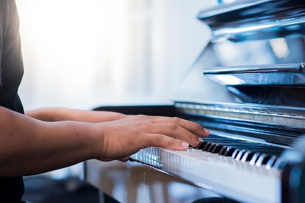 De mensenhand is piano spelen op de ochtend.