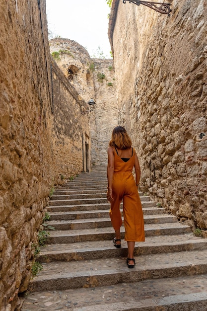 De middeleeuwse stad Girona, een jonge toerist die door de straten van de historische stad loopt