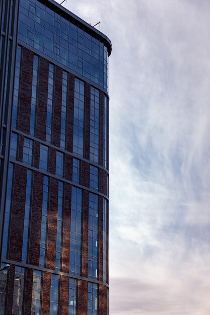 De moderne gevel van het kantoorgebouw is een abstract fragment, met glanzende ramen in een staalconstructie. Geweldige achtergrond voor een visitekaartje, flyer, banner met ruimte voor een inscriptie of logo