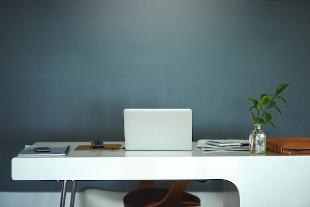 De moderne manier van werken Shot van een laptop op een bureau in een creatieve bedrijfsruimte