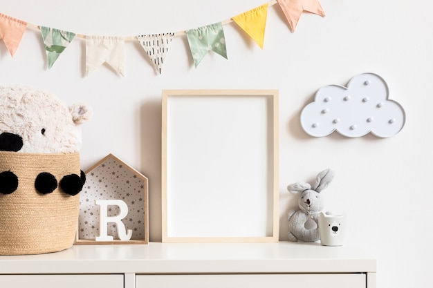 De moderne scandinavische pasgeboren babykamer met fotolijst, houten auto, knuffels en wolken