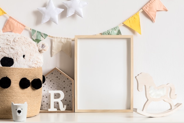 De moderne Scandinavische pasgeboren babykamer met fotolijst, houten auto, knuffels en wolken