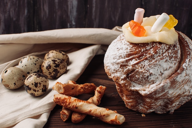 De modieuze pasen-cake met heemst en gelei draagt op een donkere rustieke houten achtergrond.