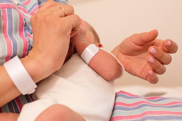 De moeder geeft haar pasgeboren baby borstvoeding op het bed