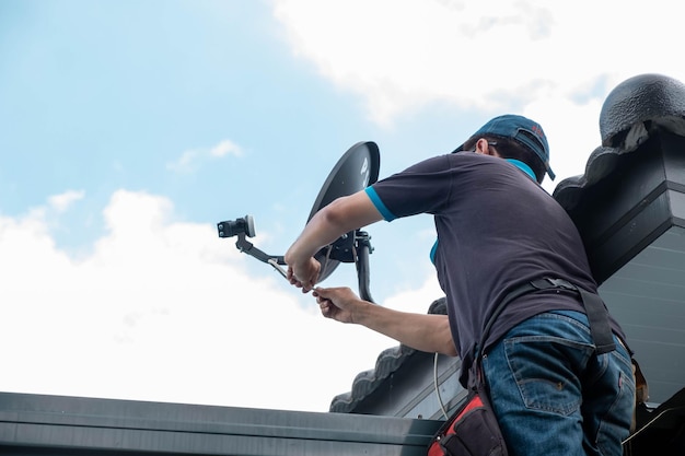 De monteur repareerde een kapotte telefoonplaat veroorzaakt door regen en windschade