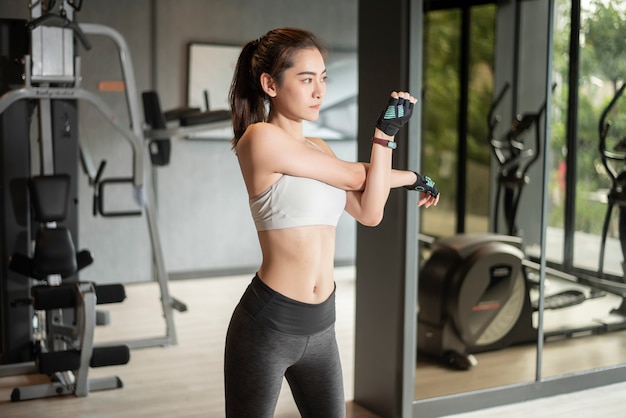 De mooie Aziatische vrouw doet oefening in de gymnastiek