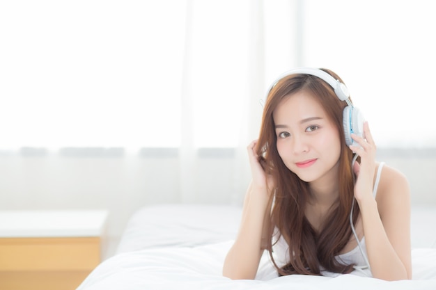 De mooie Aziatische vrouw geniet van luistermuziek met hoofdtelefoon