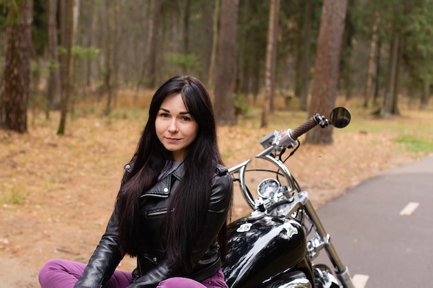 De mooie brunette op een motorfiets