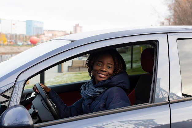 De mooie en gelukkige vrouw in de auto