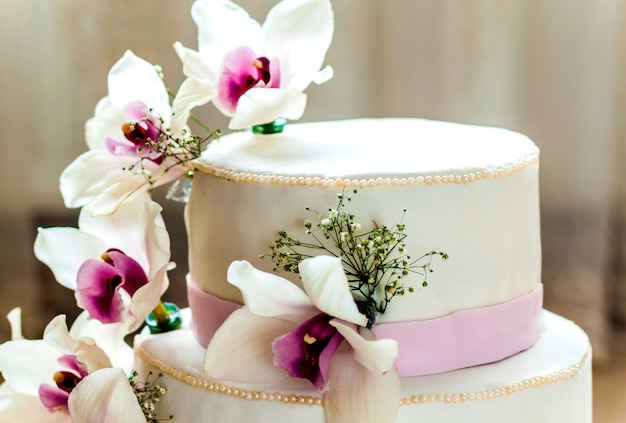 De mooie huwelijkscake met bloemen, sluit omhoog van cake met blurr