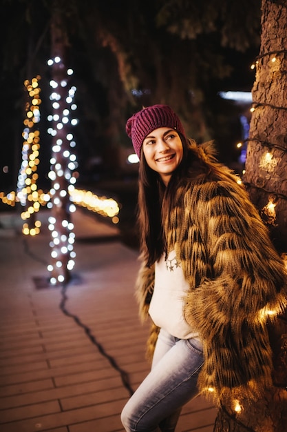 De mooie jonge dame die zich dichtbij Kerstmarkt bevindt