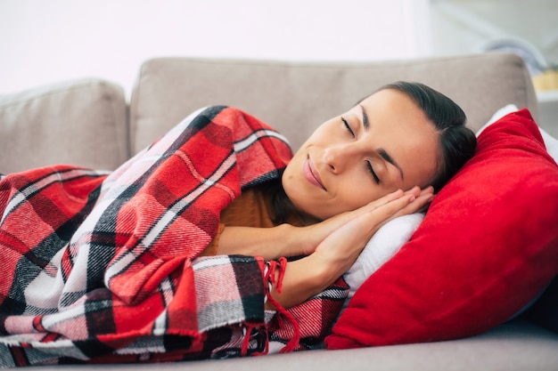 De mooie jonge vrouw ligt op de laag