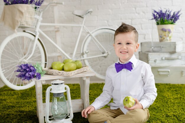 De mooie jongen met een kapsel en een blauw boeket bloemen