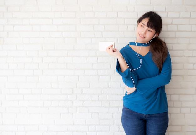 De mooie portret Aziatische jonge vrouw zich gelukkig geniet van en pret luistert muziek