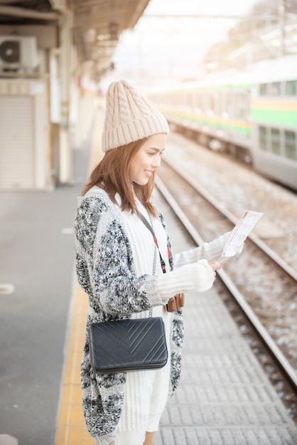 De mooie toeristenvrouw bevindt zich op Spoorwegplatform met haar Kaart