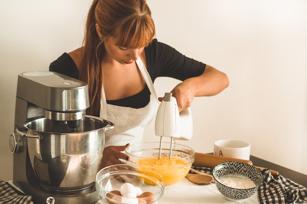 De mooie vrouw bakt muffins