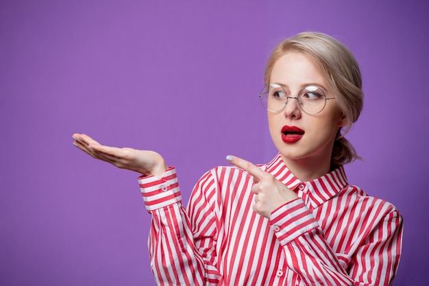 De mooie vrouw in rood gestreept overhemd houdt hand