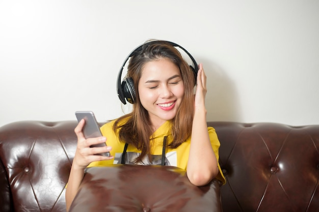 De mooie vrouw luistert muziek in huis