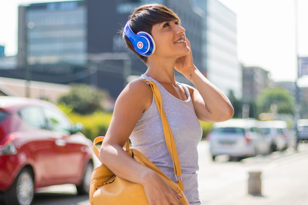 De mooie vrouw luistert muziek met hoofdtelefoon