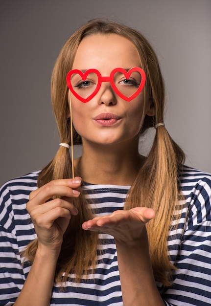 De mooie vrouw met twee staarten houdt valse glazen.