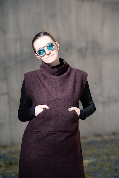 De mooie vrouw van het manierportret in modieuze kleding in de straat