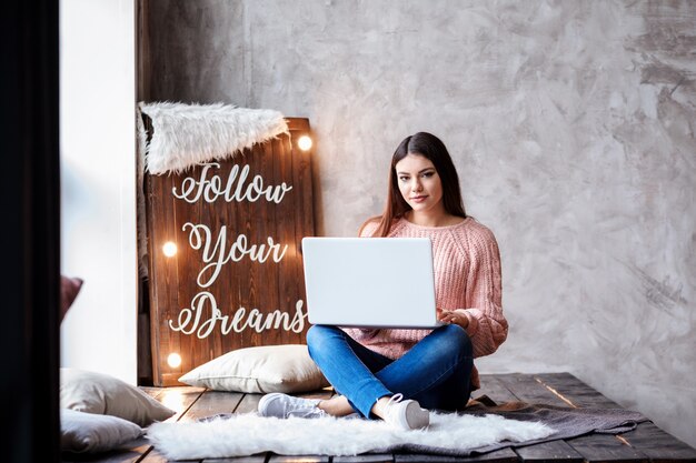 De mooie vrouw werkt, studeert thuis. Vrouwelijke freelancer, vrouw in het bedrijfsleven. Volg de motivatie van je dromen op het lichtbord.