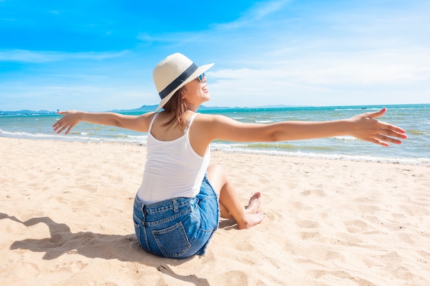 De mooie vrouw zit op strand