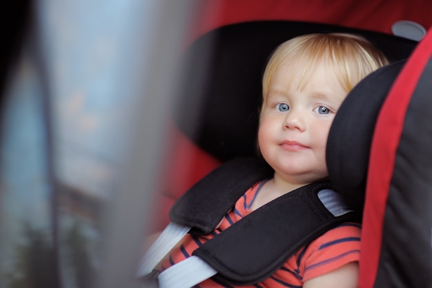 De mooie zitting van de peuterjongen in autozetel