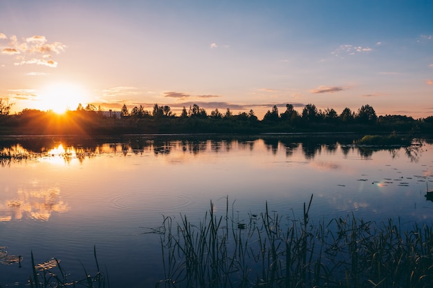 De mooie zonsondergang van de de zomerrivier met kleurrijke tinten