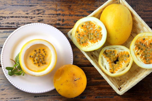 De mousse van de dessertpassievrucht in fruitschil op plaat die rustieke houten lijst verfraaien