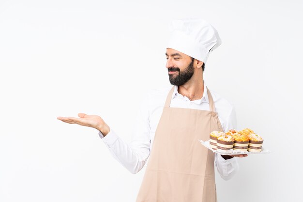 De muffincake die van de jonge mensenholding iets met twee handen houden