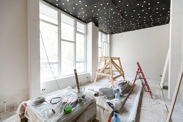 De muur van het gebouw is bedekt met vers pleisterwerk en omgeven door constructie. Achtergrond.