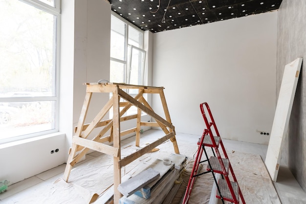 De muur van het gebouw is bedekt met vers pleisterwerk en omgeven door constructie. Achtergrond.