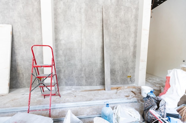 De muur van het gebouw is bedekt met vers pleisterwerk en omgeven door constructie. Achtergrond.