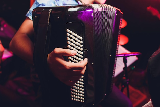 Foto de muzikant speelt de accordeon close-up microfoon