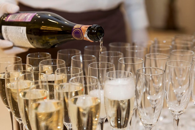 De ober schenkt champagne op de buffettafel Catering voor evenementen Feestdagen en vieringen Close-up Selectieve focus