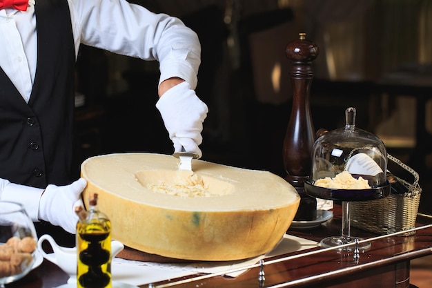 De ober snijdt stukjes Parmezaanse kaas uit