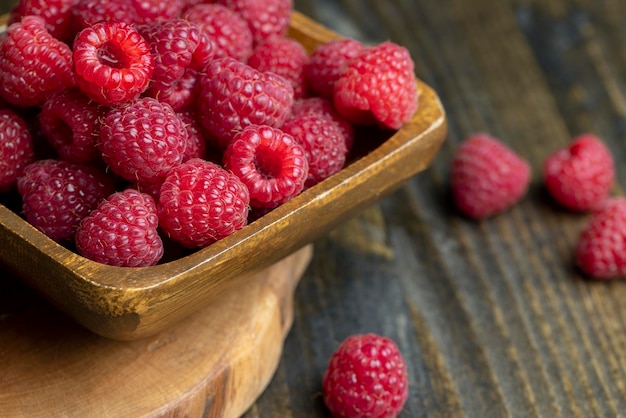 De oogst van rode rijpe frambozen staat op het bord