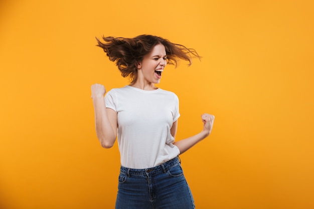 De opgewonden jonge vrouw maakt winnaargebaar.