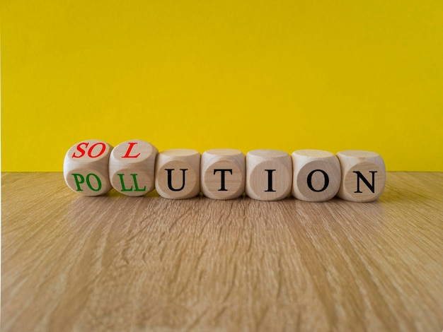 De oplossing voor het vervuilingssymbool Draaide houten blokjes om en veranderde het woord 'vervuiling' in 'oplossing'