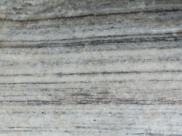 De oppervlakte van de lichtgrijze marmeren achtergrond van de steentextuur. Meer dan een miljoen jaar oud