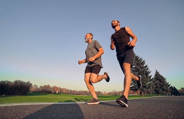 De oude en jonge sporters rennen op de steeg