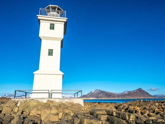 De oude inactieve vuurtoren van Arkranes aan het einde van het schiereiland werd sinds 1918 gebouwd onder de blauwe hemel IJsland