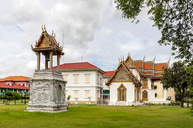 De oude klokkentoren ligt op het groene gazon van de marmeren tempel Wat Benchamabophit Dusitwanaram is een beroemde boeddhistische tempel in Bangkok Thailand die een belangrijke toeristische bestemming is